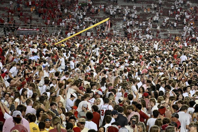 Arkansas fans rush the field to celebrate after Arkansas upsets Tennessee 19-14 during an NCAA college football game, Saturday, Oct. 5, 2024, in Fayetteville, Ark. (AP Photo/Michael Woods)