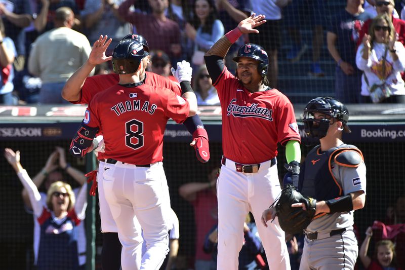 Cleveland Guardians' Lane Thomas (8) is greeted at the plate by teammates Josh Naylor, rear and third baseman Jose Ramirez, second right, in front of Detroit Tigers catcher Jake Rogers, right, after hitting a home run in the first inning during Game 1 of baseball's AL Division Series, Saturday, Oct. 5, 2024, in Cleveland. (AP Photo/Phil Long)