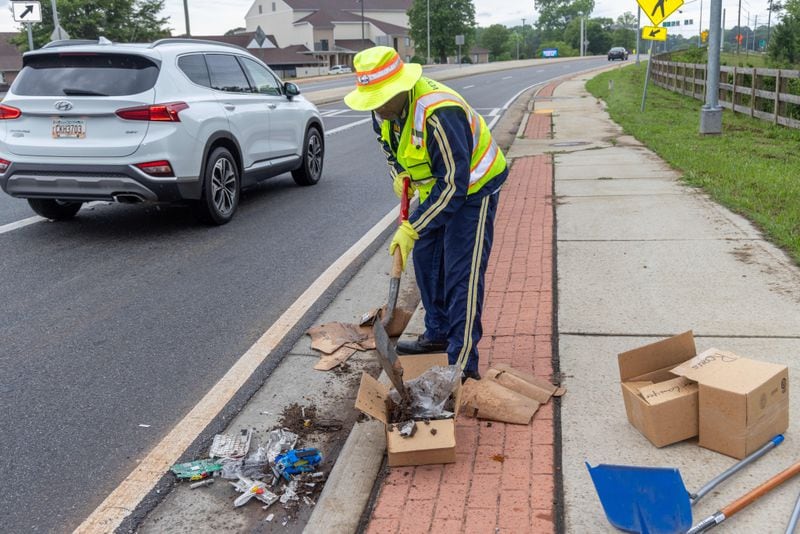 Anthony "Spark Plug" Thomas cleans up litter and debris at the Highway 92 traffic circle at Antioch and Lockwood roads in Fayetteville. PHIL SKINNER FOR THE ATLANTA JOURNAL-CONSTITUTION