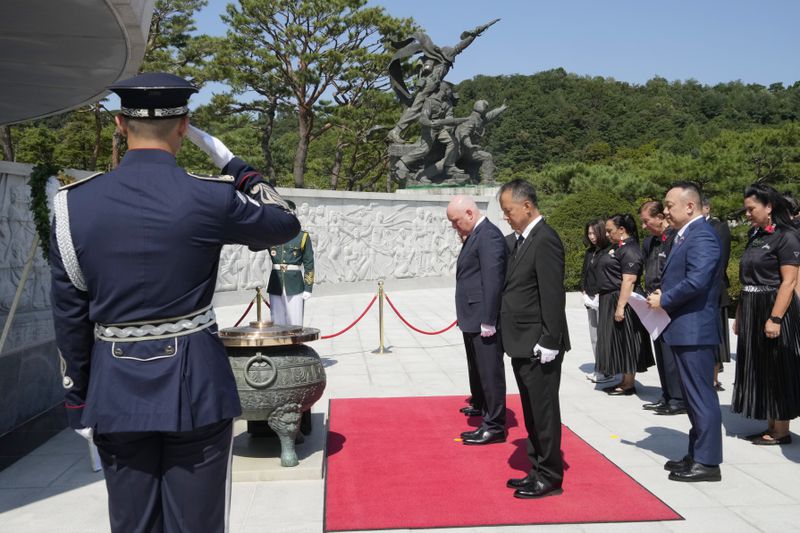 New Zealand's Prime Minister Christopher Luxon, center left, pays a silent tribute during a visit to National Cemetery in Seoul, South Korea, Wednesday, Sept. 4, 2024. (AP Photo/Ahn Young-joon)