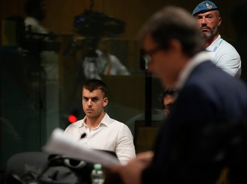 Gabriel Natale Hjorth listens to his lawyer Francesco Petrelli during a hearing for the appeals trial in which he is facing murder charges for killing Italian Carabinieri paramilitary police officer Mario Cerciello Rega, in Rome, Wednesday, July 3, 2024. Two American men face a new trial in the slaying of an Italian plainclothes police officer during a botched sting operation after Italy's highest court threw out their convictions. (AP Photo/ Alessandra Tarantino)
