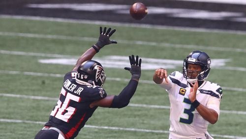 Seattle Seahawks quarterback Russell Wilson completes a first-down pass under pressure from Atlanta Falcons defensive end Dante Fowler during the second half Sunday, Sept. 13, 2020 in Atlanta.  (Curtis Compton / Curtis.Compton@ajc.com)