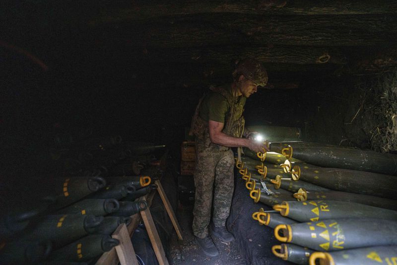 Ukrainian serviceman Oleh of 148th separate artillery brigade of the Air Assault Forces prepares 155mm artillery shells before firing towards Russian positions at the frontline in Donetsk region, Ukraine, Wednesday, August 21, 2024. (AP Photo/Evgeniy Maloletka)