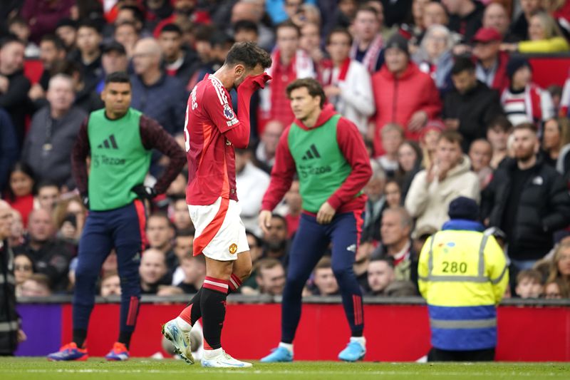 Manchester United's Bruno Fernandes walks off the pitch after receiving the red card for a foul during the English Premier League soccer match between Manchester United and Tottenham Hotspur at Old Trafford stadium in Manchester, England, Sunday, Sept. 29, 2024. (AP Photo/Dave Thompson)