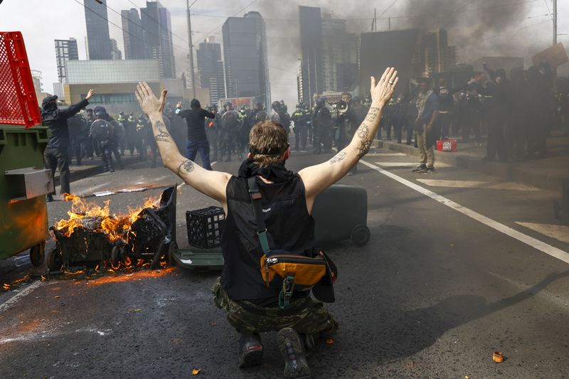 A protester gestures to Victorian police at an anti-war protest outside a military arms convention in downtown Melbourne, Australia, Wednesday, Sept. 11, 2024. (Con Chronis/AAP Image via AP)