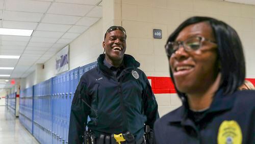 04/17/2018 -- Sandy Springs, GA - Riverwood International Charter School police officer Donald Rene, left, and Fulton County School Police Detective Angela Washington, right, share a laugh while walking the halls of Riverwood International Charter School in Sandy Springs, Tuesday, April 17, 2018. ALYSSA POINTER/ALYSSA.POINTER@AJC.COM