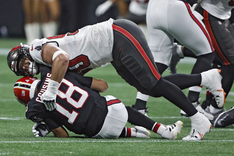 Tampa Bay Buccaneers defensive end Logan Hall (90) sacks Atlanta Falcons quarterback Kirk Cousins (18) during the first half of an NFL football game Thursday, Oct. 3, 2024, in Atlanta. (AP Photo/Butch Dill)