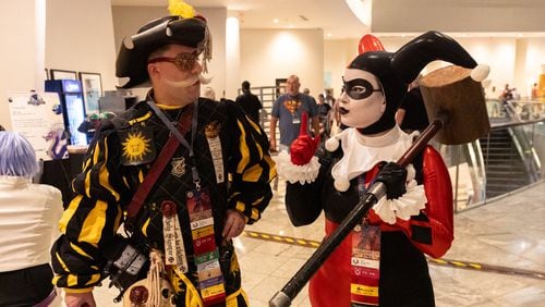 James and Nicole Pitts, cosplaying as a Warhammer character and Harley Quinn, walk through the Marriott Marquis during Dragon Con in downtown Atlanta on Friday, August 30, 2024. The five-day convention continues through Monday. (Arvin Temkar / AJC)