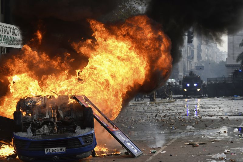 A vehicle burns during clashes between anti-government protesters and police outside Congress, where lawmakers debate a reform bill promoted by Argentine President Javier Milei in Buenos Aires, Argentina, Wednesday, June 12, 2024. (AP Photo/Gustavo Garello)
