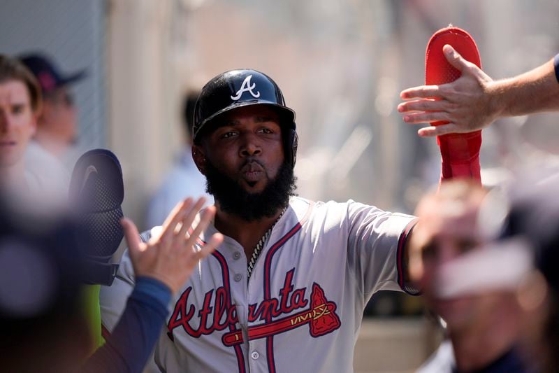 Atlanta Braves designated hitter Marcell Ozuna celebrates in the dugout after scoring off a sacrifice fly by Jarred Kelenic during the eighth inning of a baseball game against the Los Angeles Angels, Sunday, Aug. 18, 2024, in Anaheim, Calif. (AP Photo/Ryan Sun)