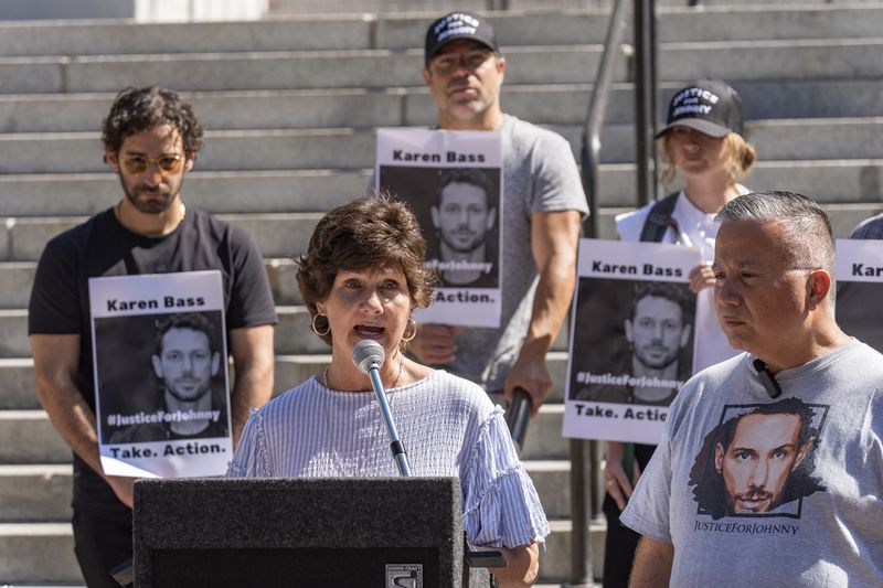 Scarlett Wactor, the mother of late actor Johnny Wactor, speaks during a news conference outside Los Angeles City Hall in Los Angeles, Tuesday, Aug. 13, 2024. asking citizens to help find the suspects that murdered the former "General Hospital" actor. At right, detective Moses Castillo. (AP Photo/Damian Dovarganes)