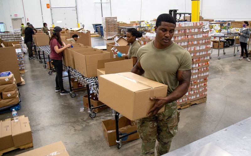 National Guard Pfc. Onyekachukwu Enenmuo weighs boxes of supplies at the Atlanta Community Food Bank headquarters Friday, May 22, 2020. STEVE SCHAEFER FOR THE ATLANTA JOURNAL-CONSTITUTION