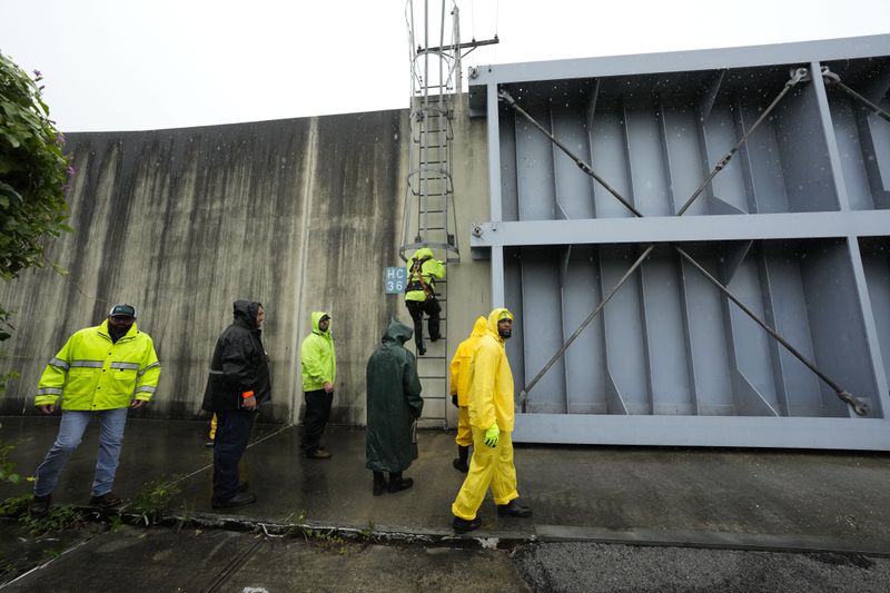 Workers from the Southeast Louisiana Flood Protection Authority-West close floodgates along the Harvey Canal, just outside the New Orleans city limits, in anticipation of Tropical Storm Francine, in Harvey, La., Tuesday, Sept. 10, 2024. (AP Photo/Gerald Herbert)