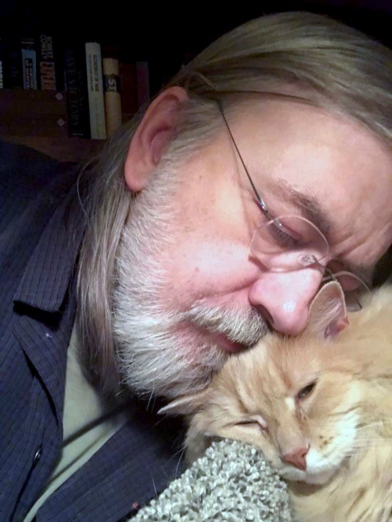 This undated self portrait made available by Little Brown publisher, shows author Caleb Carr and his cat Masha at his home in Cherry Plain, NY. Carr died of cancer Thursday, May 23, 2024, according to his publisher, Little, Brown and Company. (Caleb Carr/ Little Brown via AP)