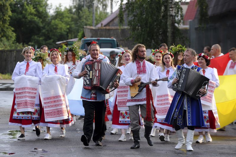 FILE - Belarusians in national costumes walk to the Berezina River in a ritual marking the summer solstice in the village of Parichi, about 200 kilometers (125 miles) southeast of Minsk, Belarus, on July 6, 2022. (AP Photo, File)