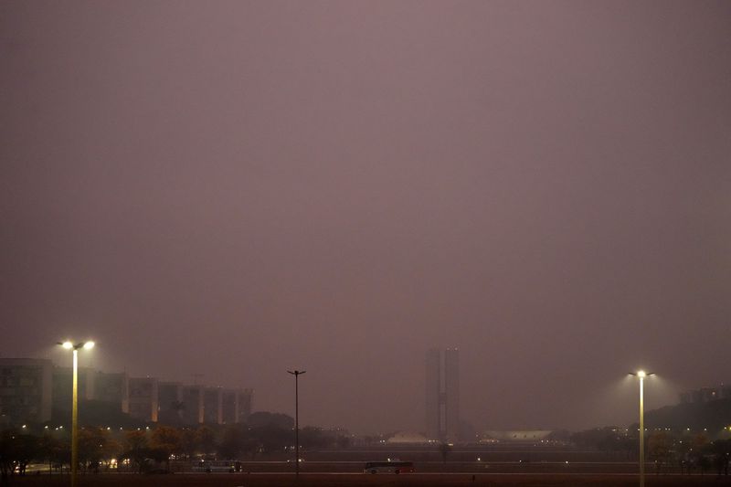 The National Congress is barely visible through smoke from wildfires during dry weather in Brasilia, Brazil, early Monday, Aug. 26, 2024. (AP Photo/Eraldo Peres)