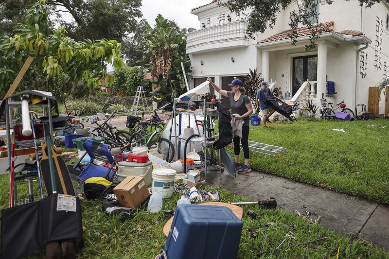 Ellie Moss, along with family and friends cleans contents of her home after flooding from Hurricane Helene on Davis Island Saturday, Sept. 28, 2024, in Tampa, Fla. (AP Photo/Mike Carlson)