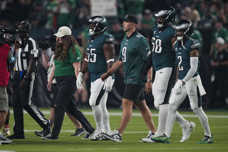 Former Philadelphia Eagles' Nick Foles, third from right, walks with Philadelphia Eagles' Brandon Graham, from left, Jordan Mailata and Darius Slay Jr. as they honor Foles' retirement before an NFL football game against the Atlanta Falcons on Monday, Sept. 16, 2024, in Philadelphia. (AP Photo/Matt Rourke)