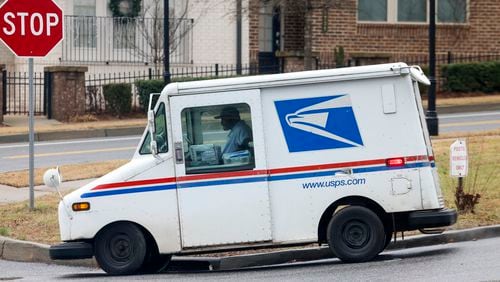 A U.S. Postal Service employee seen on the job near Dunwoody Village Pkwy Thursday, Jan. 19, 2023. The Postal Service has suspended operations at scores of its facilities across Georgia in the wake of Hurricane Helene, reigniting fears about its ability to process hundreds of thousands of mail-in ballots in time for this year’s presidential election. Jason Getz / Jason.Getz@ajc.com)