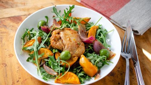 Tender boneless, skinless chicken thighs combined with spicy harissa, sweet honey, thinly sliced clementines, zesty red onion and buttery green olives are served atop arugula. (Virginia Willis for The Atlanta Journal-Constitution)