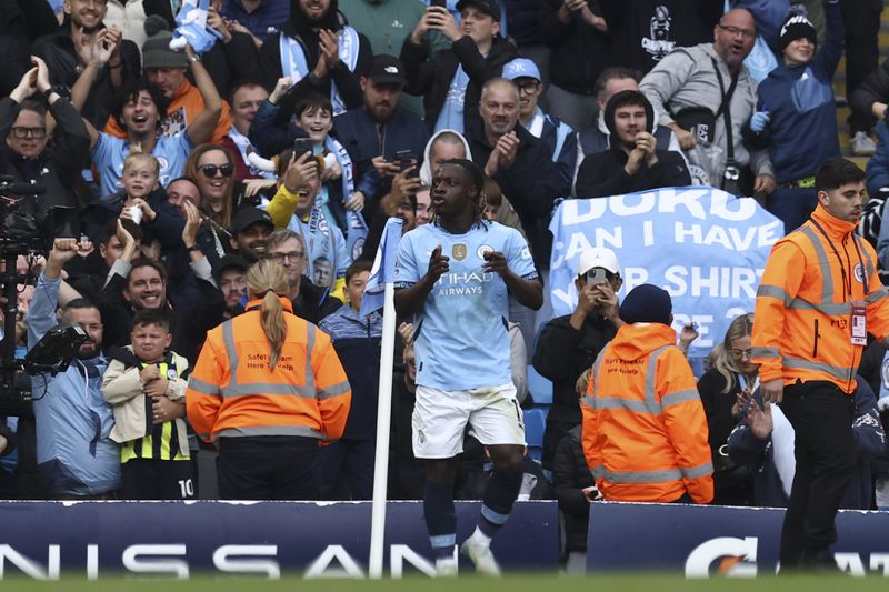 Manchester City's Jeremy Doku celebrates after scoring his side's third goal during the English Premier League soccer match between Manchester City and Fulham at Etihad Stadium in Manchester, England, Saturday, Oct. 5, 2023. (AP Photo/Darren Staples)