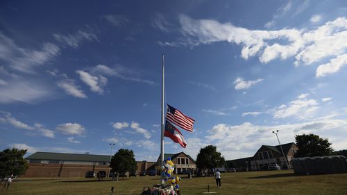 Flags fly at half mast outside the Apalachee High School as community members pay respect on Thursday, Sept. 5, 2025.  A 14-year-old is accused of shooting and killing two fellow students and two teachers and injuring nine others at Apalachee High School on Wednesday.
(Miguel Martinez / AJC)