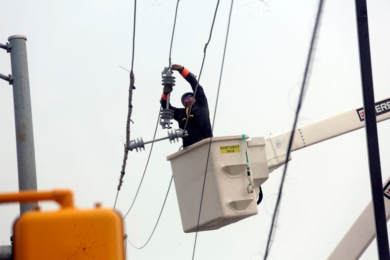 Utility crews work to restore electricity in Houston, Thursday, July 11, 2024. Officials say about 500,000 customers still won't have electricity into next week as wide outages from Hurricane Beryl persist. (AP Photo/Lekan Oyekanmi)