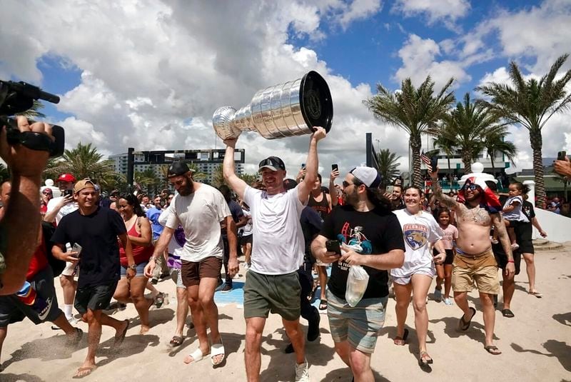 Florida Panthers NHL hockey player Sam Bennett heads to the Atlantic Ocean with the Stanley Cup in Fort Lauderdale, Fla., Tuesday, June 25, 2024. The Panthers beat the Edmonton Oilers 2-1 on Monday night in Game 7 of the Stanley Cup Final. (Joe Cavaretta/South Florida Sun-Sentinel via AP)