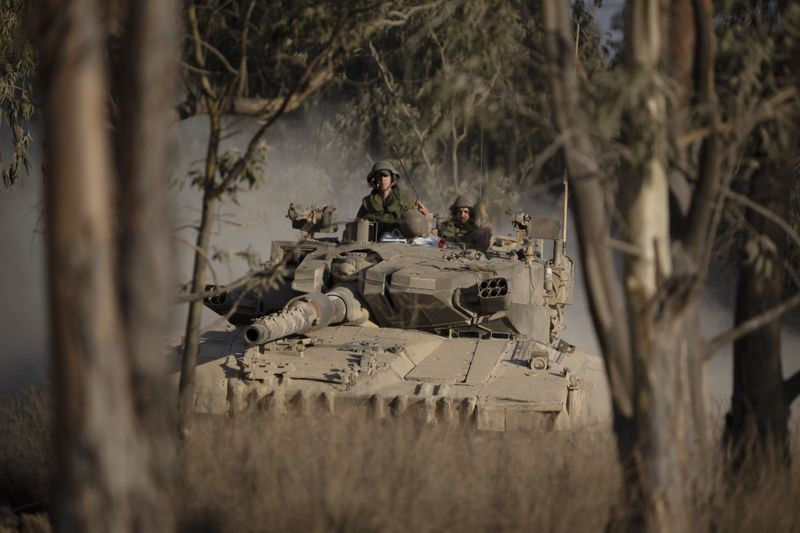 Israeli soldiers move on the top of a tank near the Israeli-Gaza border, as seen from southern Israel, Saturday, June 29, 2024. (AP Photo/Leo Correa)
