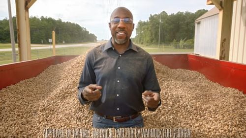 In a campaign ad aimed at showcasing Raphael Warnock's bipartisan work on behalf of Georgia's peanut farmers, he was showered with thousands of peanuts.