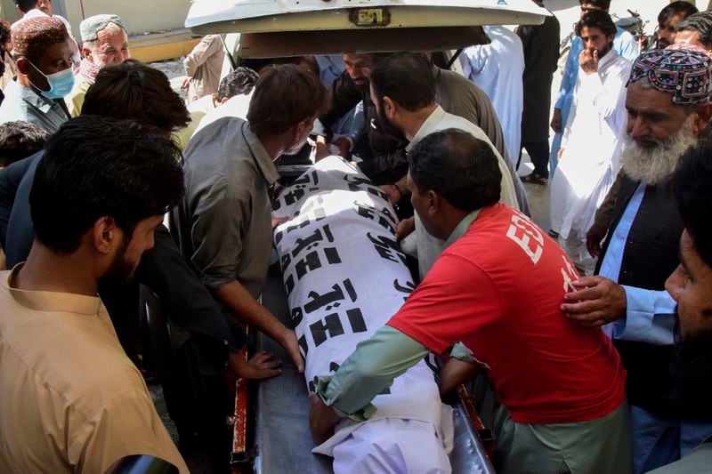 Volunteers and relatives load the body of a passenger, who was killed by gunmen at a highway in Musakhail, into a vehicle after collecting it from a hospital, in Quetta, Pakistan, Monday, Aug. 26, 2024. (AP Photo/Arshad Butt)