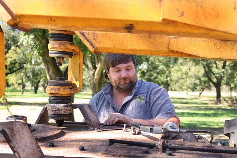 Cason Anderson greases a part of the shaker. (Eric Dusenbery for The Atlanta Journal-Constitution)