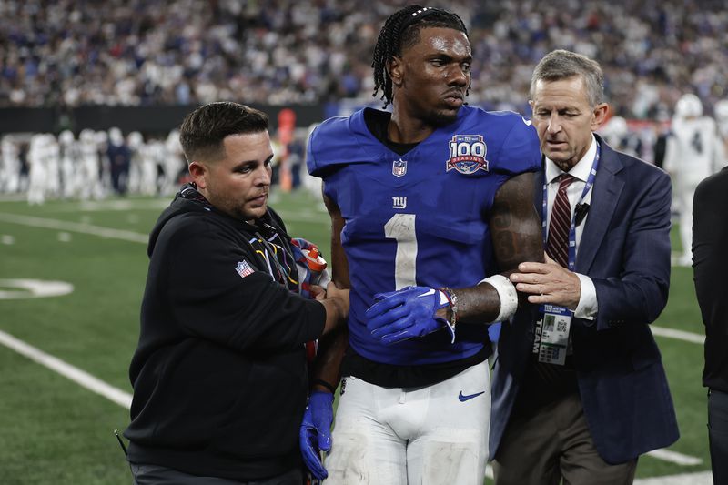 New York Giants wide receiver Malik Nabers (1) is helped off the field after an injury during the fourth quarter of an NFL football game against the Dallas Cowboys, Thursday, Sept. 26, 2024, in East Rutherford, N.J. (AP Photo/Adam Hunger)