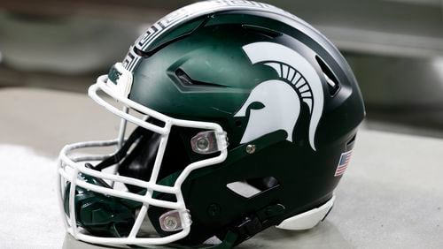 FILE - A Michigan State football helmet is seen during an NCAA college football game against Penn State on Nov. 24, 2023, in Detroit. Three years into the new age of college sports, where athletes are allowed to profit from their successes through name, image and likeness deals, everyone is still trying to find out what the new normal will be. (AP Photo/Al Goldis, File)