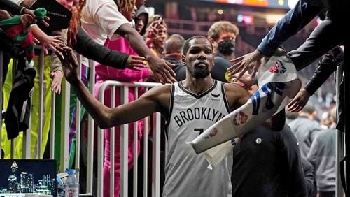 Brooklyn Nets forward Kevin Durant (7) makes his way past fans as he walks to the locker room after the Nets defeated the Atlanta Hawks in an NBA basketball game Friday, Dec. 10, 2021, in Atlanta. (AP Photo/John Bazemore)