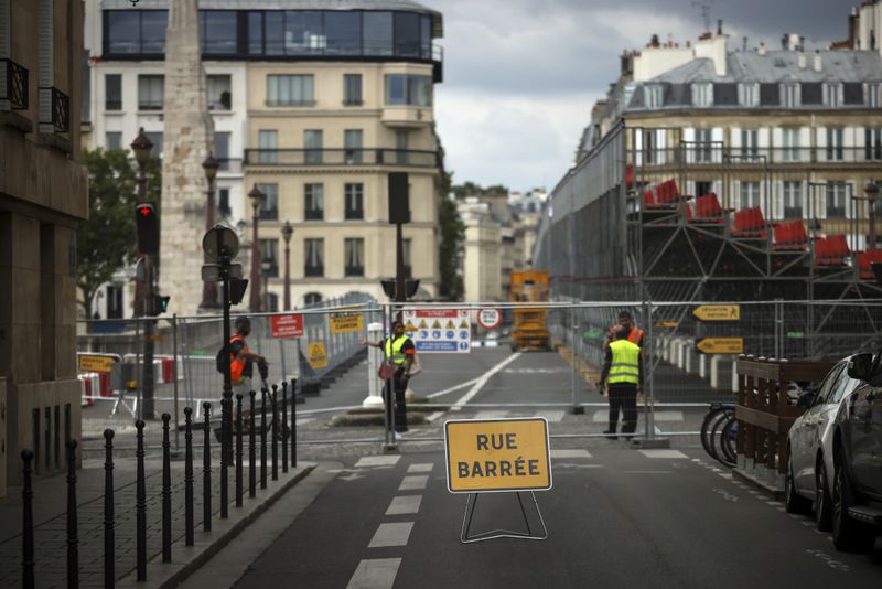 FILE - Security officers stand at the security perimeter of a closed street at the 2024 Summer Olympics, July 21, 2024, in Paris, France. (AP Photo/Thomas Padilla, File)