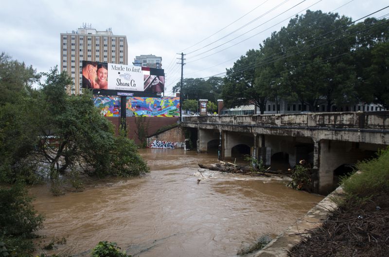 An overpass above a swollen and rushing Peachtree Creek, the site of a major Civil War battle, is seen overflowing its lower banks after Hurricane Helene passed the area on Friday, Sept. 27, 2024, in Atlanta. (AP Photo/Ron Harris)