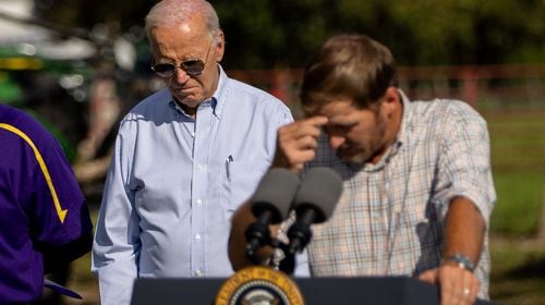 President Joe Biden (left) visited South Georgia to survey damage from Hurricane Helene on Thursday. He said the federal government was working to meet the needs of families and businesses affected by the storm, which tore a path through the Southeast roughly a week ago. He bows his head as pecan farmer Buck Paulk says a prayer at his farm in Ray City on Thursday, Oct. 3, 2024. (Arvin Temkar/AJC)