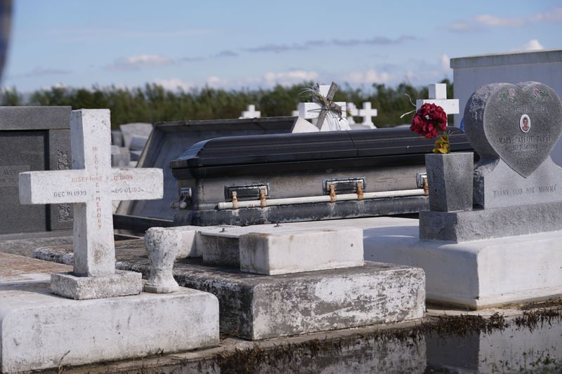 A casket sits on tombs after being disturbed by flooding, in the aftermath of Hurricane Francine, in Dulac, La., Thursday, Sept. 12, 2024. (AP Photo/Gerald Herbert)