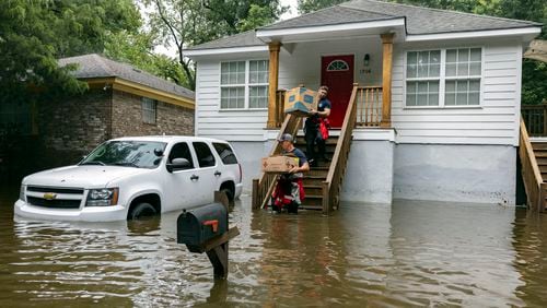 Savannah Fire Advanced Firefighters Ron Strauss, top, and Andrew Stevenson, below, carry food to residents in the Tremont Park neighborhood that where stranded in stormwater from Tropical Storm Debby, Tuesday, Aug. 6, 2024, in Savannah, Ga. (AP Photo/Stephen B. Morton)