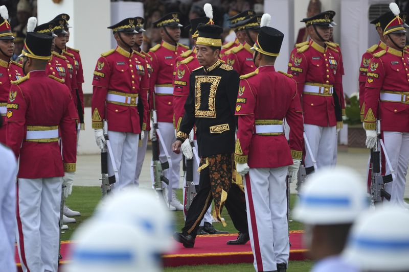 Indonesian President Joko Widodo walks among members of a honor guard during the ceremony marking Indonesia's 79th anniversary of independence at the new presidential palace in its future capital of Nusantara, a city still under construction on the island of Borneo, Saturday, Aug. 17, 2024. (AP Photo/Achmad Ibrahim)