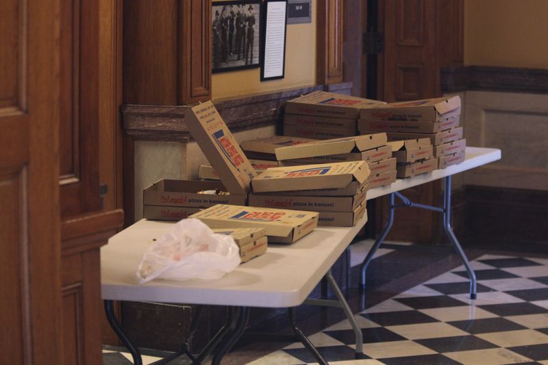 Pizza boxes sit on tables outside the entrances to the Kansas House chamber to provide lunch for members as they debate a proposal for luring the Kansas City Chiefs from Missouri, Tuesday, June 18, 2024, at the Statehouse in Topeka, Kansas. The proposal would authorize state bonds to help finance a new stadiums for the Chiefs and Major League Baseball's Kansas City Royals in Kansas. (AP Photo/John Hanna)