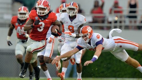 Georgia running back Todd Gurley eludes the tackle of Clemson's  Adrien Dunn en route to a 100-yard kickoff return against Clemson on Saturday, August 30, 2014 in Athens.  BRANT SANDERLIN / AJC file 
.