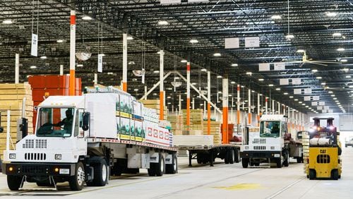 A driver prepares to pull a flatbed trailer out of a Home Depot Flatbed Distribution Center in Lithonia. Home Depot recorded record earnings on the back of th strength of the housing renocation market. Bloomberg photo by Elijah Nouvalege.