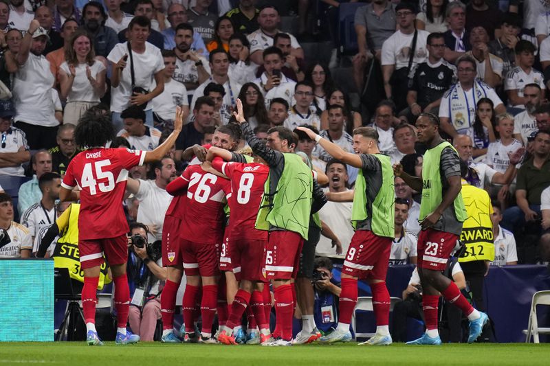 Stuttgart players celebrate their side's first goal during the Champions League opening phase soccer match between Real Madrid and VfB Stuttgart at the Santiago Bernabeu stadium, in Madrid, Tuesday, Sept. 17, 2024. (AP Photo/Manu Fernandez)