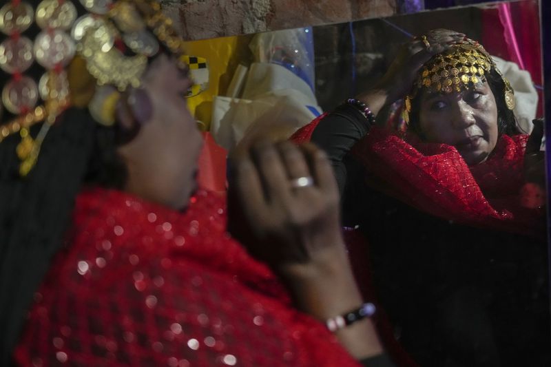 Sudanese Camirata troupe dancer Hoda Othman puts makeup on before their show at the Russian culture center in Cairo, Egypt, Sunday, Sept. 15, 2024. (AP Photo/Amr Nabil)