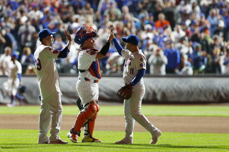 New York Mets relief pitcher Edwin Diaz, left, catcher Francisco Alvarez, center, and second baseman Jose Iglesias celebrate after a baseball game against the Philadelphia Phillies Sunday, Sept. 22, 2024, in New York. (AP Photo/John Munson)