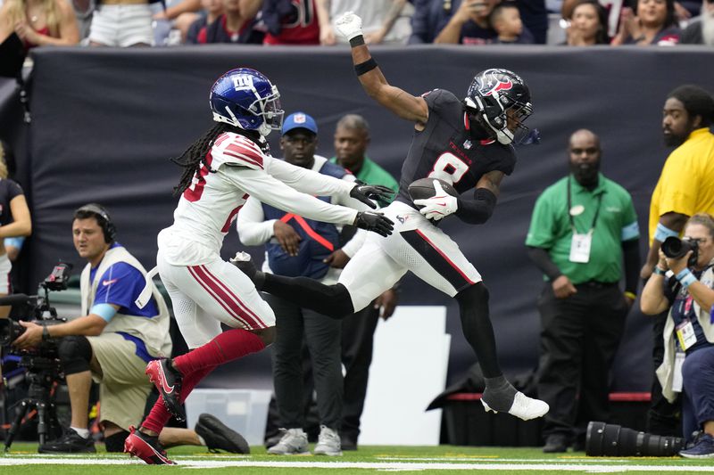 Houston Texans wide receiver John Metchie III (8) catches a pass in front of New York Giants cornerback Tre Herndon (23) in the first half of a preseason NFL football game, Saturday, Aug. 17, 2024, in Houston. (AP Photo/Eric Gay)