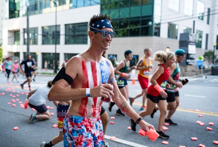 A runner participates in the 55th running of The Atlanta Journal-Constitution Peachtree Road Race at "Cardiac Hill" on Peachtree Road NW in Atlanta on Thursday, July 4, 2024. (Seeger Gray / AJC)