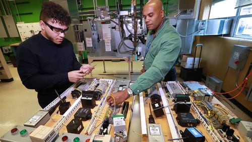 Building automation instructor Robert Croom works with student Adam Lovell on a controller board with input/output devices during a class in the Building Automation Systems program at Georgia Piedmont Technical College on Thursday, Jan. 30, 2020, in Clarkston.CURTIS COMPTON / CCOMPTON@AJC.COM